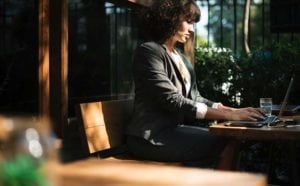 Sole Proprietor business woman sitting at table working on laptop